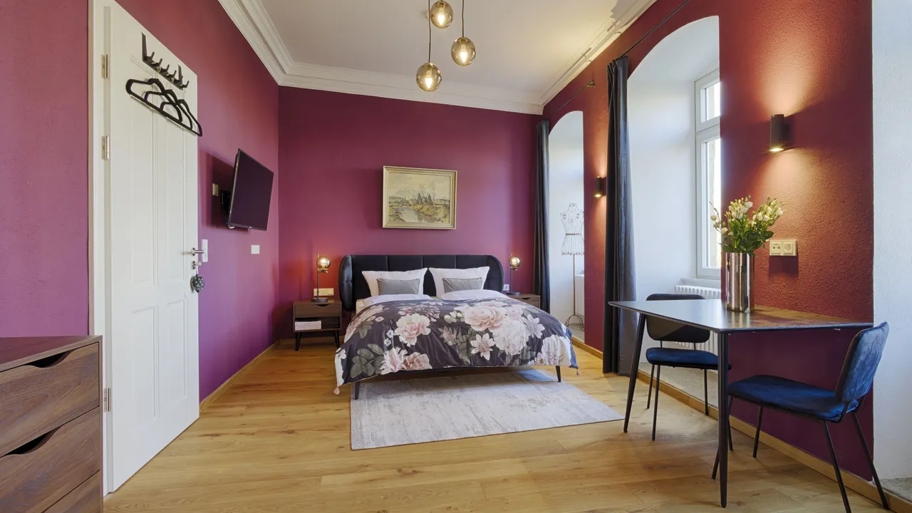 Das gemütliche Tapferes Schneiderlein Zimmer mit Bett, kleinem Esstisch und Küche in den Grimms Schlossapartments.