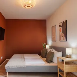 Das Schlafzimmer in unserem roten Apartment bietet genug Platz für einen komfortablen Aufenthalt. 